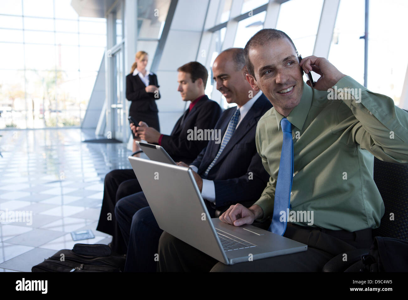 Businessman on cell phone using laptop Stock Photo