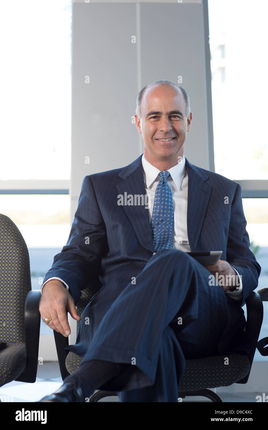 Mature businessman sitting in chair Stock Photo