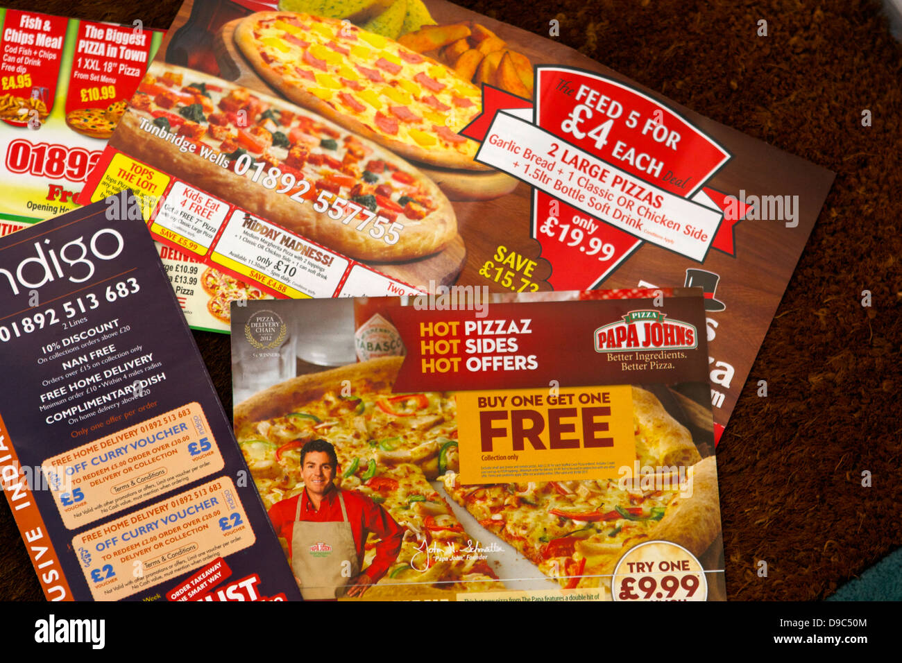 A week's worth of fast-food flyers on the doormat Stock Photo