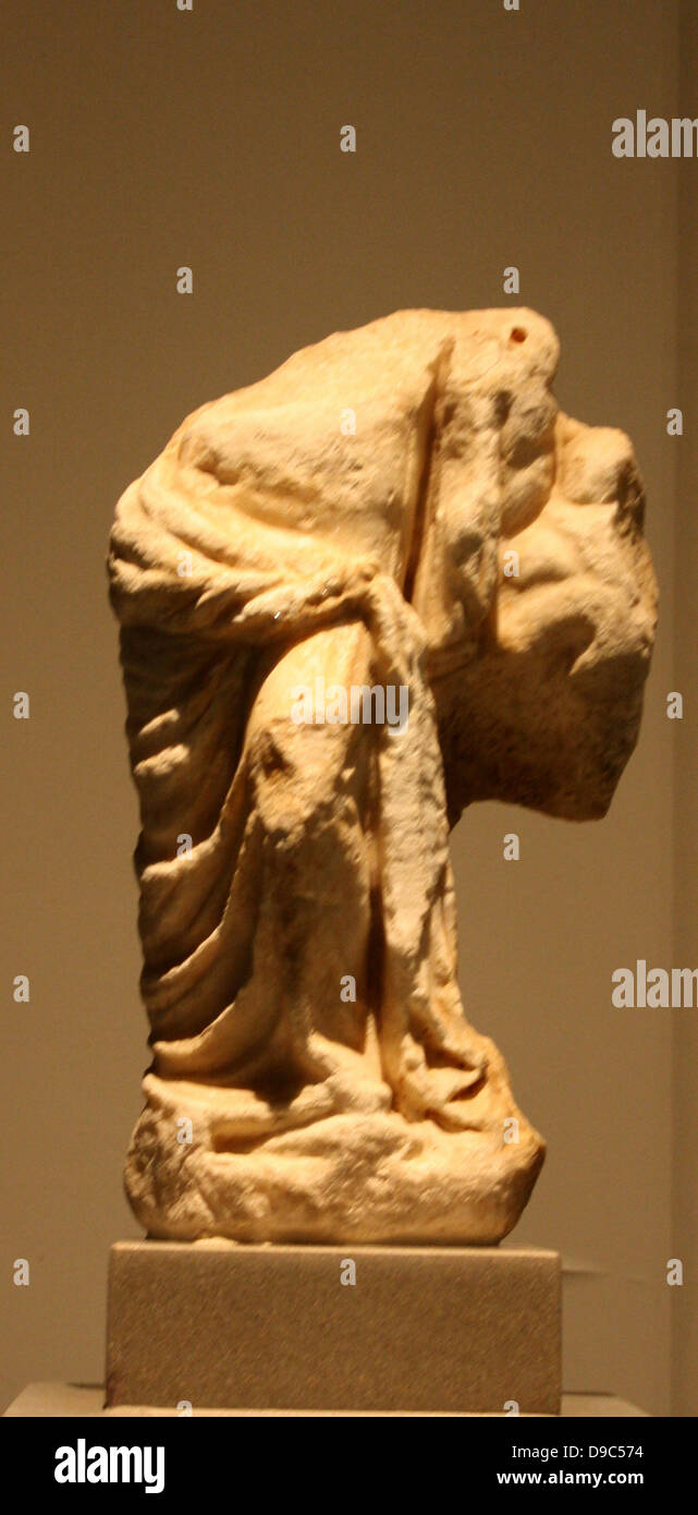 Marble statuette of Aphrodite.  From Athens, 2nd c BC  The goddess wears a himation only over the lower body and leans against the cavern of a rock, behind which appears Eros.  Setting alludes to the sanctuaries on the North slope of the Acropolis. Stock Photo