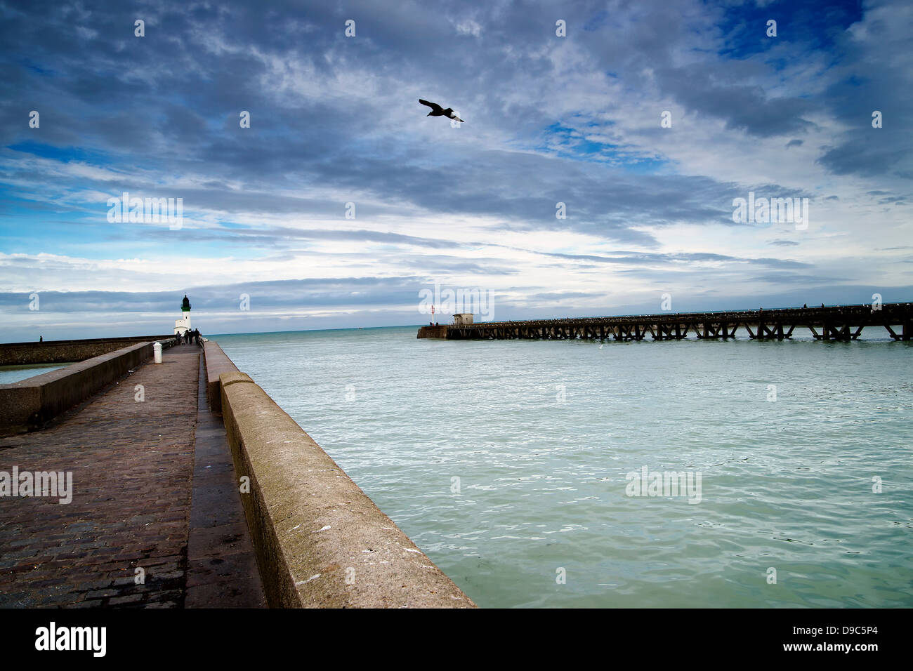 Harbor wall and wooden pier Stock Photo