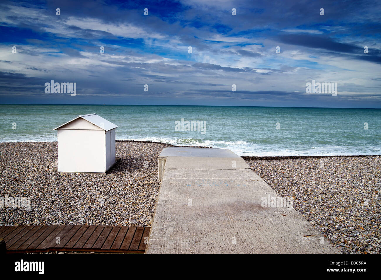 White beach hut on shingle beach Stock Photo