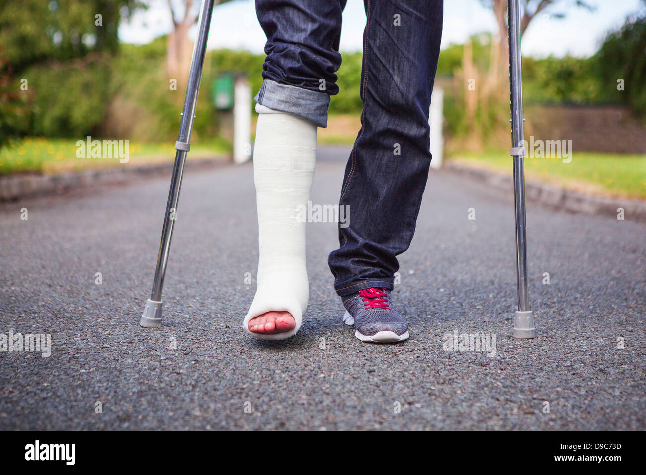 Image of someone standing with crutches because of broken ankle. Stock Photo