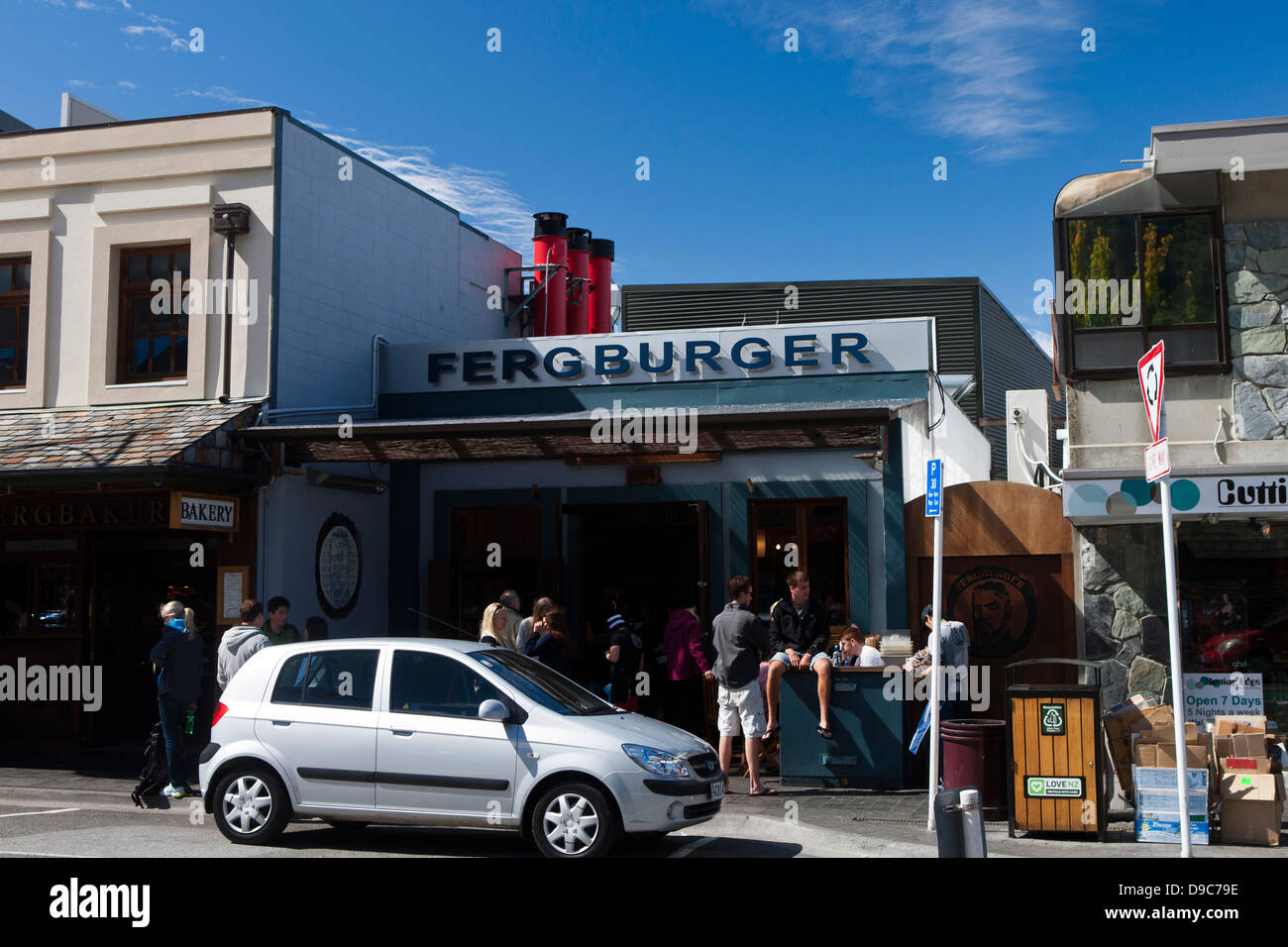 Patrons sit outside of Fergburger burger restaurant, Queenstown, South Island, New Zealand Stock Photo