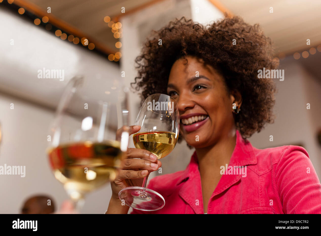 Woman raising wine glass to drink Stock Photo - Alamy