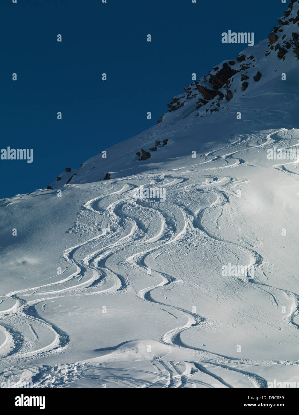 Ski tracks in snow on mountain Stock Photo