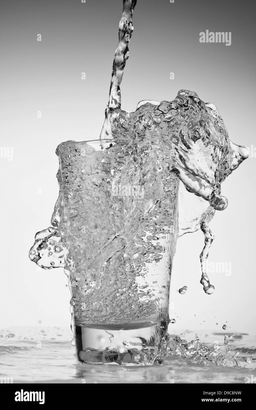 Pouring water overflowing glass Black and White Stock Photos & Images ...