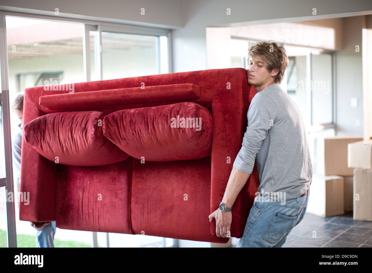 Young men carrying sofa Stock Photo Alamy