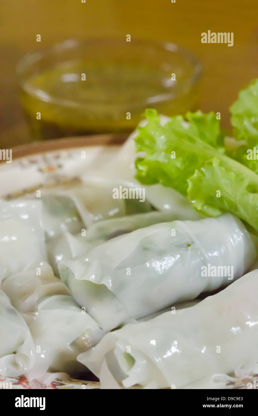 Chinese rice noodle roll served with lettuce and chili sauce Stock Photo