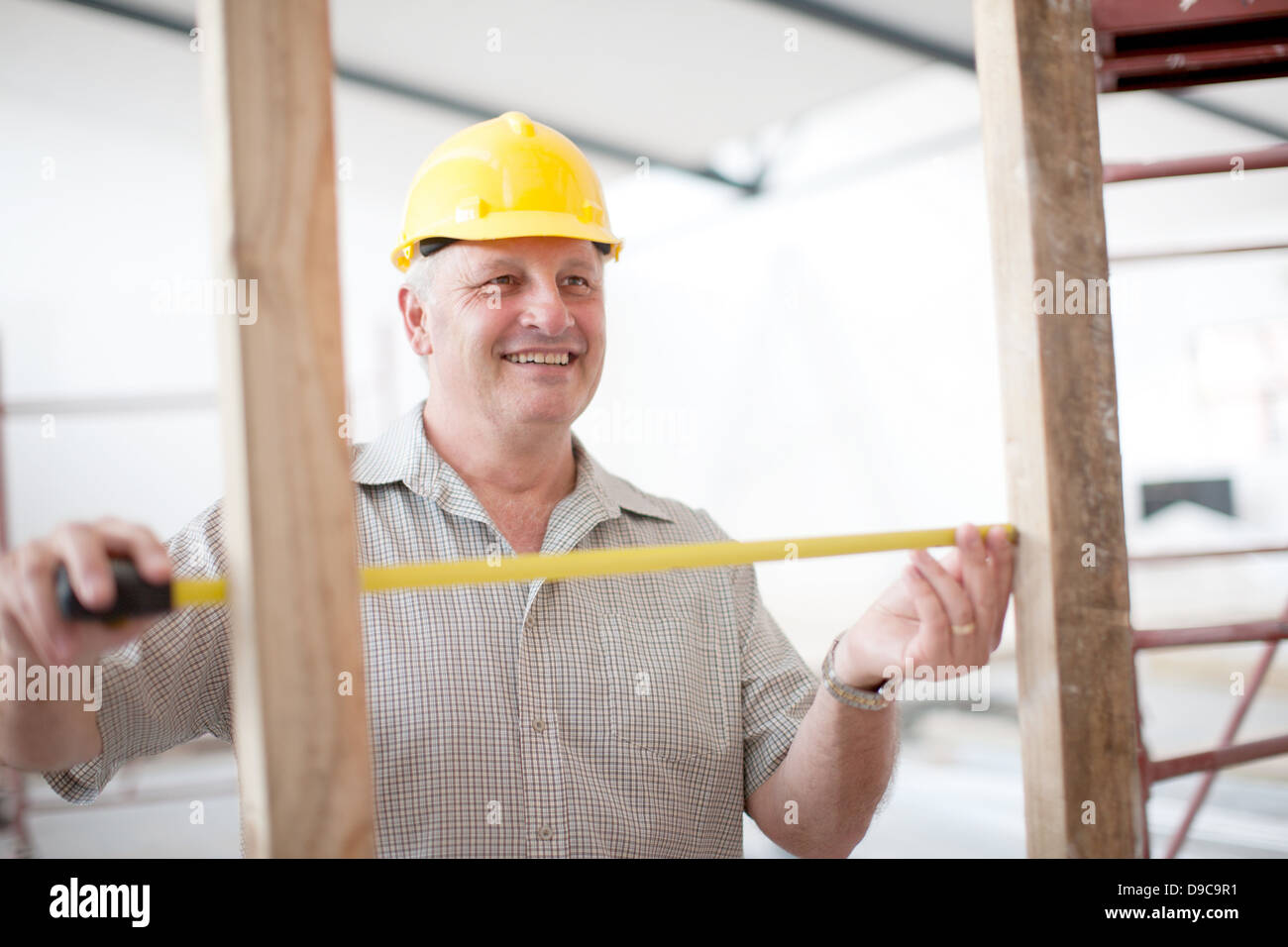 Builder measuring construction frame Stock Photo Alamy
