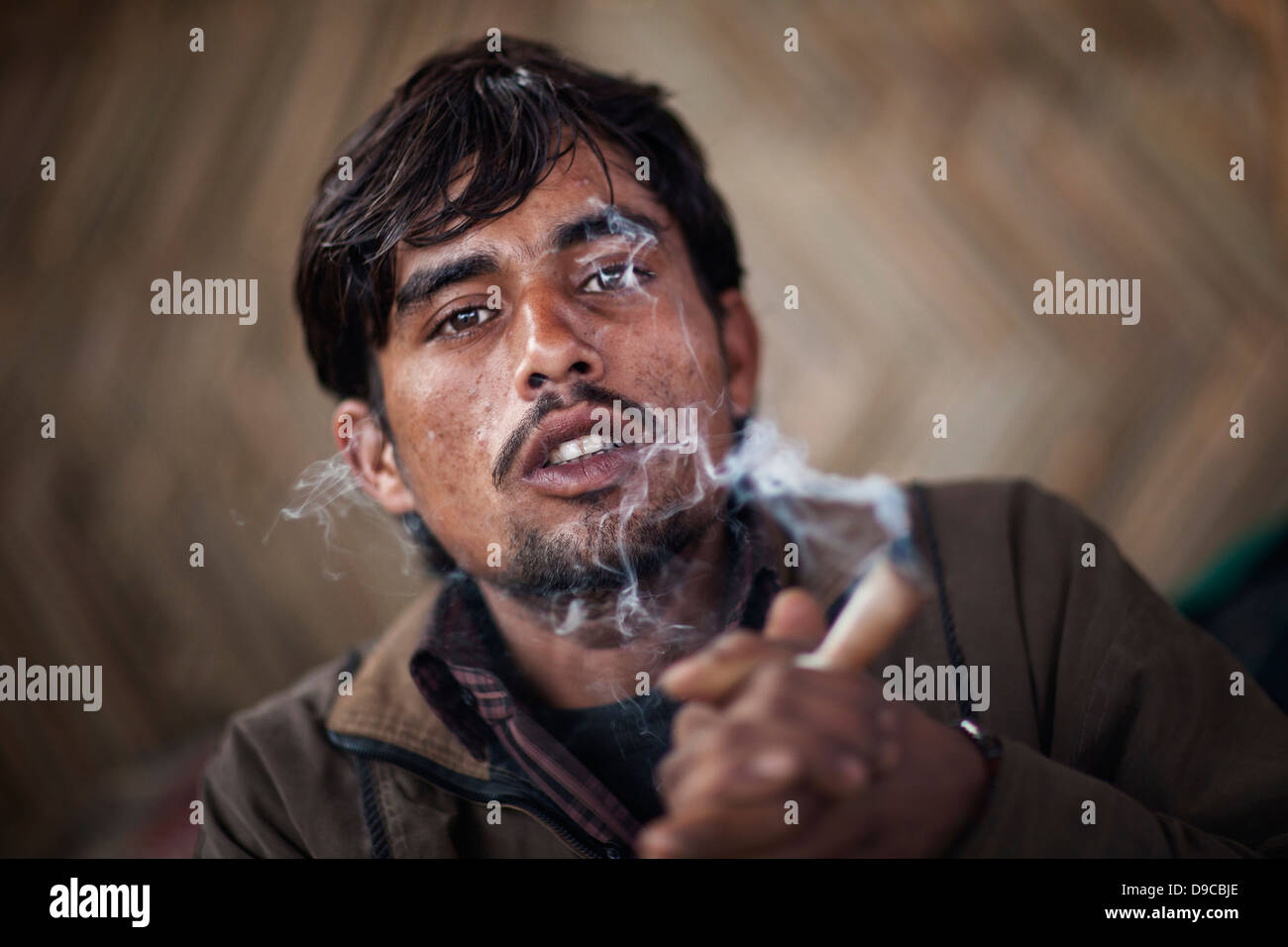 Young Rural Smokers Portrait of a local villager smoking a pipe at the Kumbh Mela 2013 in ...