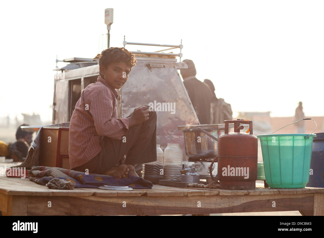 Young boy working at a food stand at the Kumbh Mela in India Stock Photo