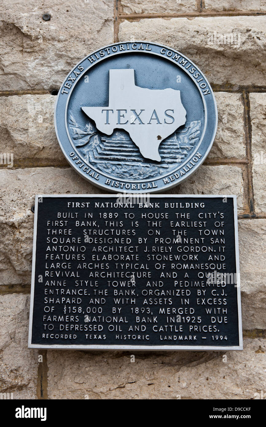 FIRST NATIONAL BANK BUILDING Built in 1889 to house the city's first bank, this is the earliest of three structures on the town square designed by prominent San Antonio architect J. Riely Gordon. It features elaborate stonework and large arches typical of Romanesque Revival architecture and a Queen Anne style tower and pedimented entrance. The bank, organized by C. J. Shapard and with assets in excess of $158,000 by 1893, merged with Farmers National Bank in 1925 due to depressed oil and cattle prices. Recorded Texas Historic Landmark - 1994 Stock Photo