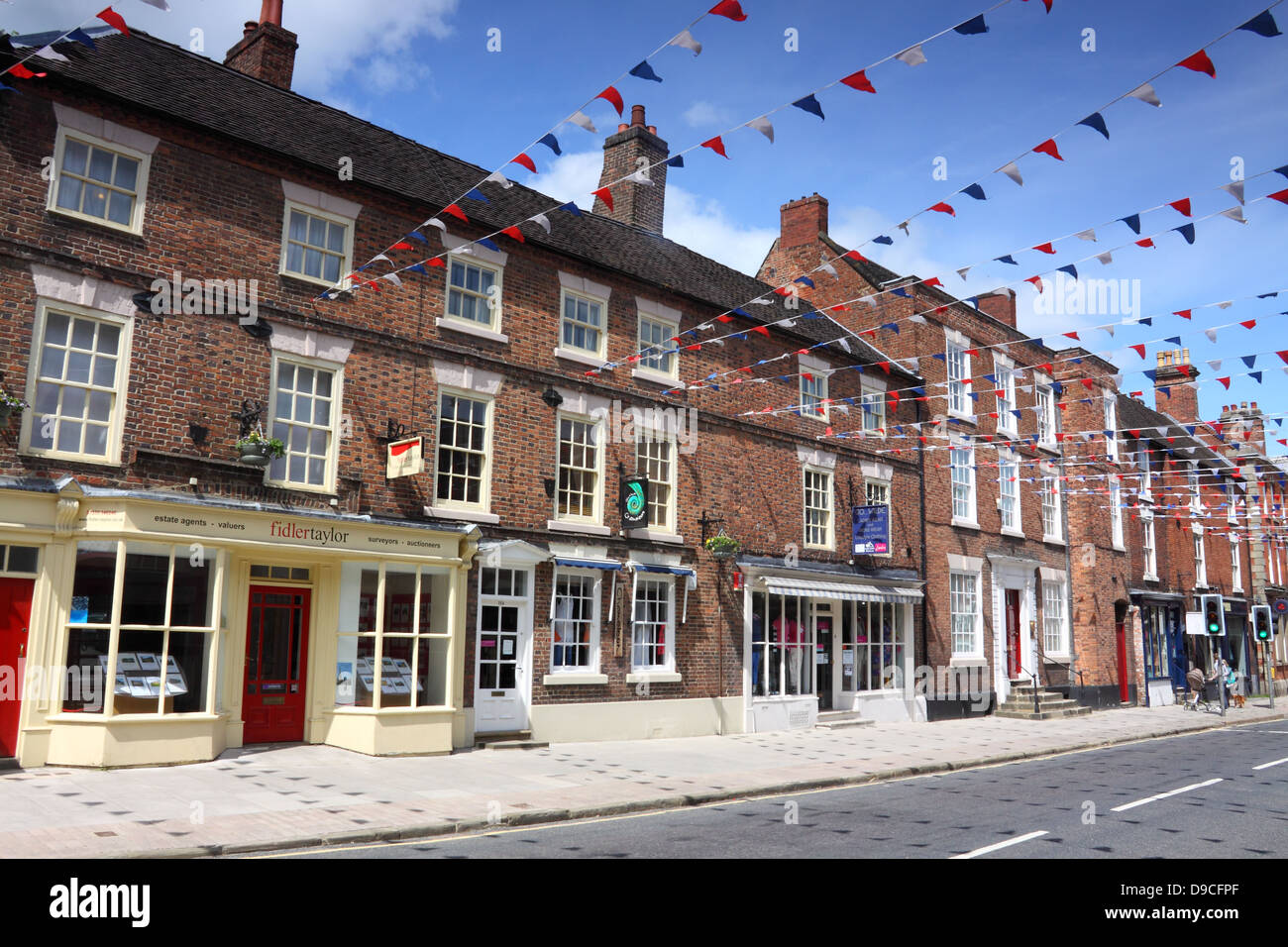 Bunting strung between shops in the pretty market town of Ashbourne, Derbyshire, England Stock Photo