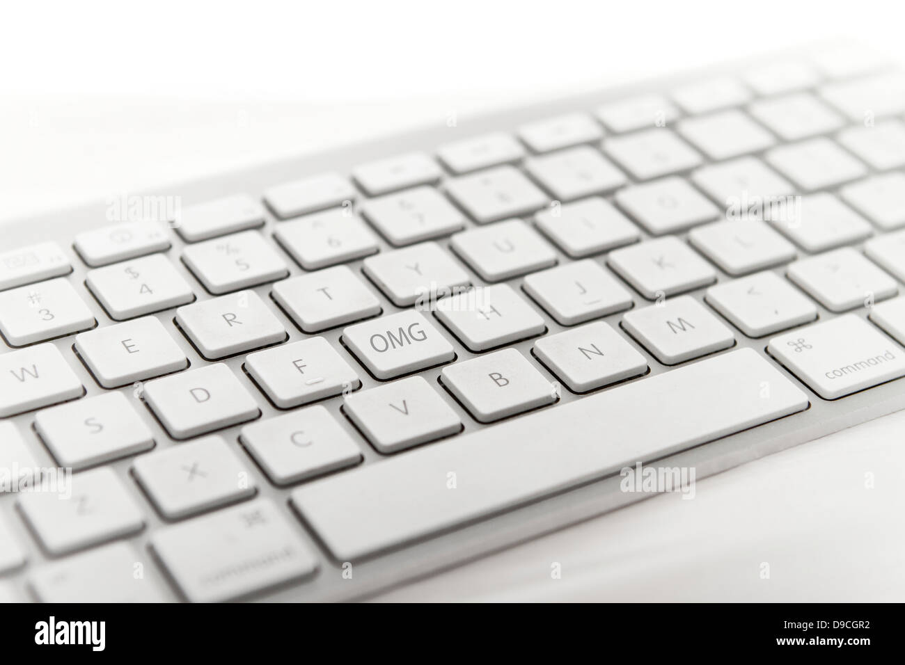 Apple wireless computer keyboard with one key changed to show the abbreviation OMG (oh my god) Stock Photo