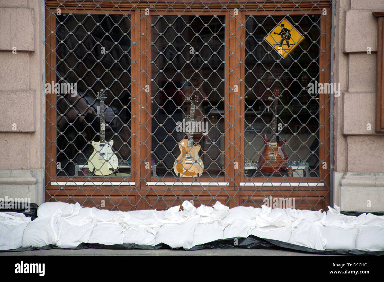 Sandbags lining the wall of a music shop with guitars in the window to protect from the flooding River Danube, Budapest, Hungary Stock Photo