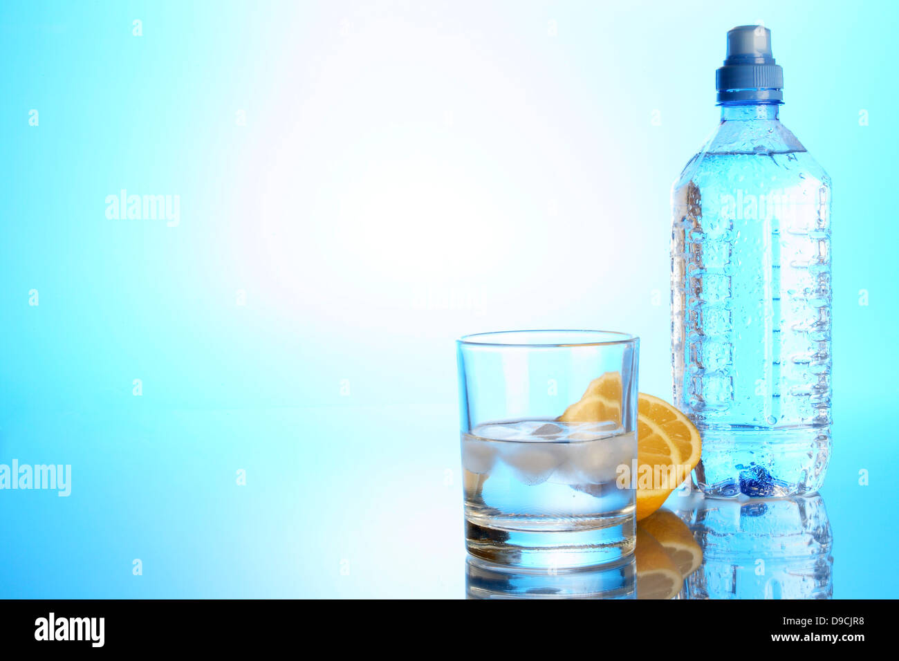 Bottle of mineral water, water glass and lemon Stock Photo