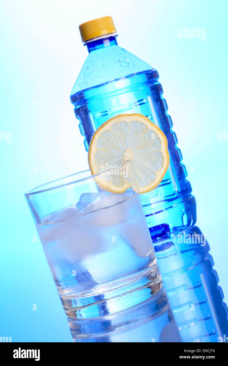 Water glass with lemon and water bottle Stock Photo