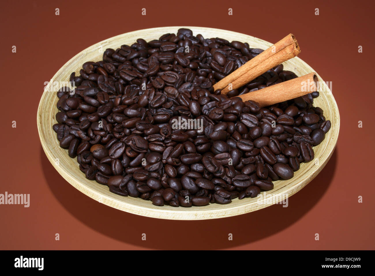 Coffee beans with cinnamon sticks in a bowl Stock Photo