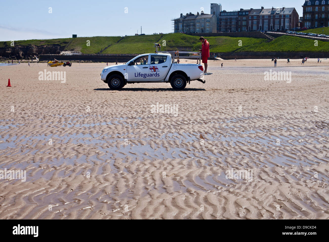 Life guard on the Tynemouth Beach looking out a the North Sea with coastal houses behind Stock Photo