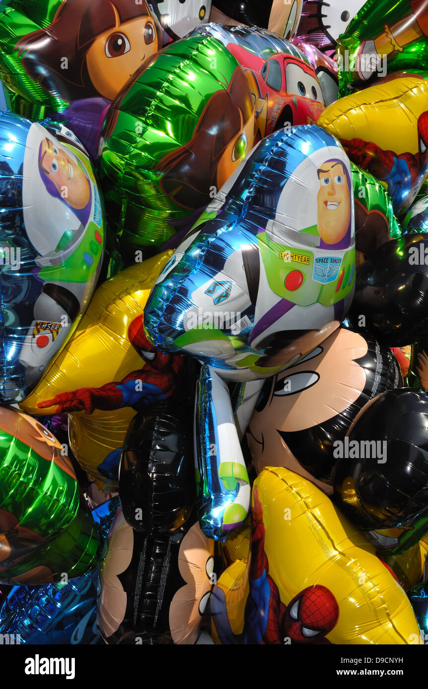 Helium filled Cartoon foil balloons floating in a bunch. Stock Photo