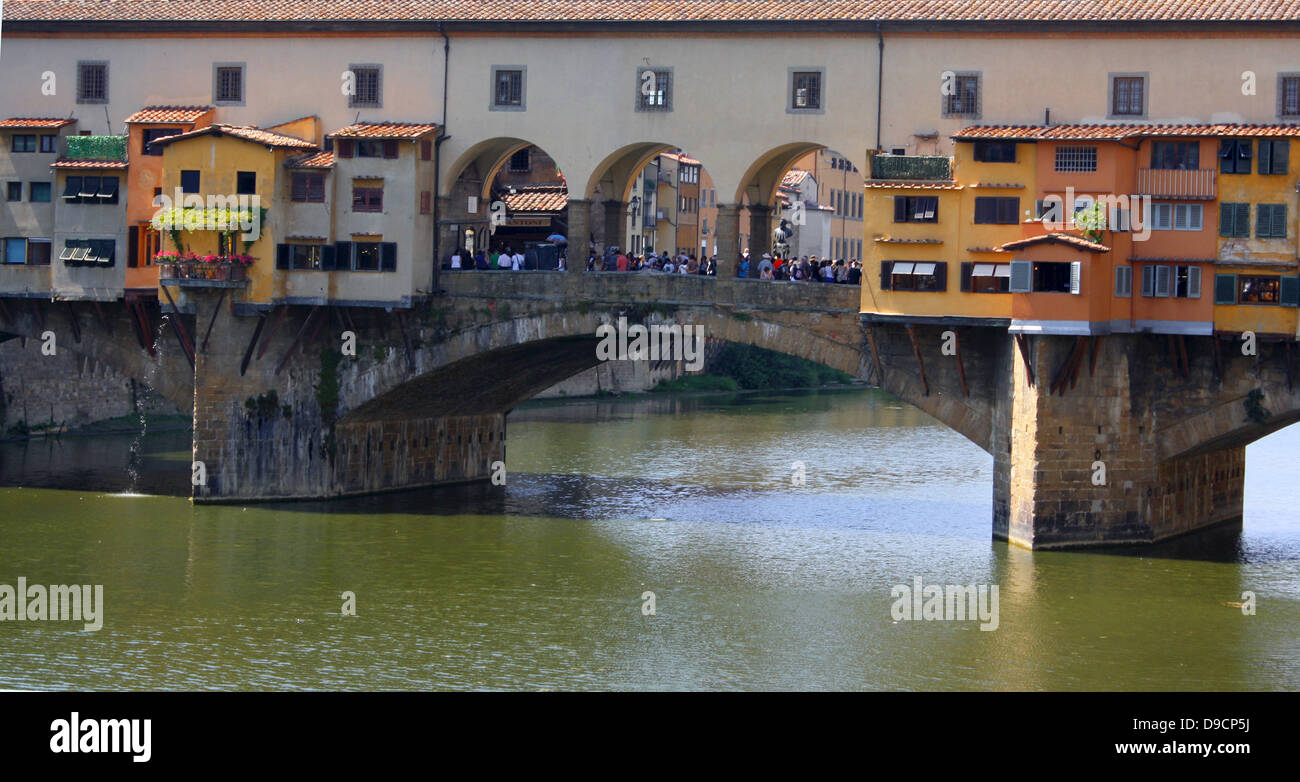 The Ponte Vecchio medieval stone closed-spandrel segmental arch bridge over the Arno River, in Florence, Italy, noted for still having shops built along it, as was once common. It was rebuilt in 1345 Stock Photo