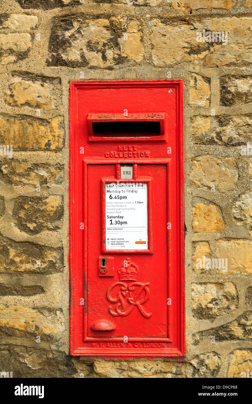 Red Royal Mail letter box embedded in stone wall George VI, Peterborough, England Stock Photo