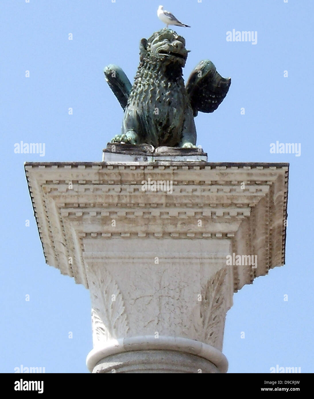 The Piazzetta di San Marco is  an open space connecting the south side of the Piazza to the waterway of the lagoon. The Piazzetta lies between the Doge's Palace on the east and Jacopo Sansovino's Libreria which holds the Biblioteca Marciana on the west. The column has a creature representing the winged lion which is the symbol of St Mark. This has a long history, probably starting as a winged lion-griffin on a monument to the god Sandon at Tarsus in Cilicia (Southern Turkey) about 300 BC. The columns are now thought to have been erected about 1268, Stock Photo