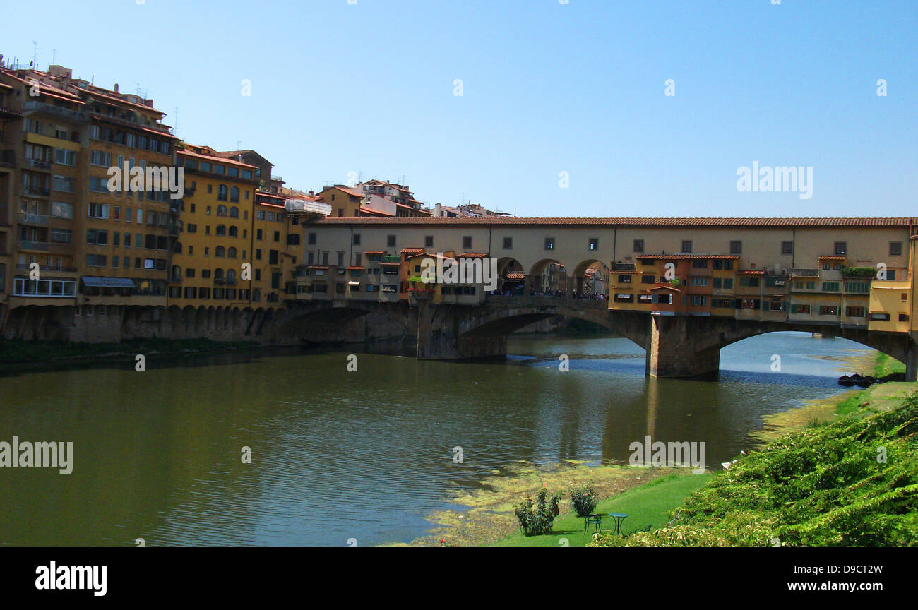 The Ponte Vecchio medieval stone closed-spandrel segmental arch bridge over the Arno River, in Florence, Italy, noted for still having shops built along it, as was once common. It was rebuilt in 1345 Stock Photo