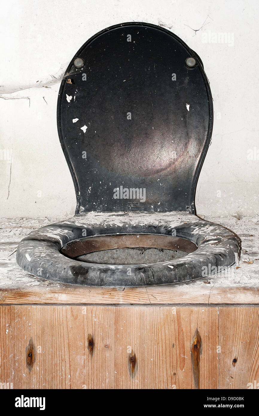 Open toilet lid in an old toilet house, Open toilet eyelid toilet in in old house Stock Photo