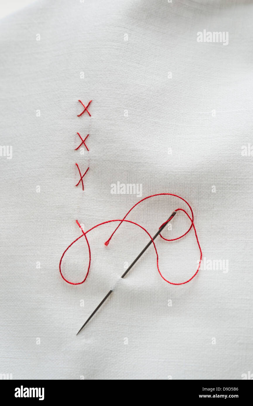 Embroidery cross on fabric with red thread Stock Photo