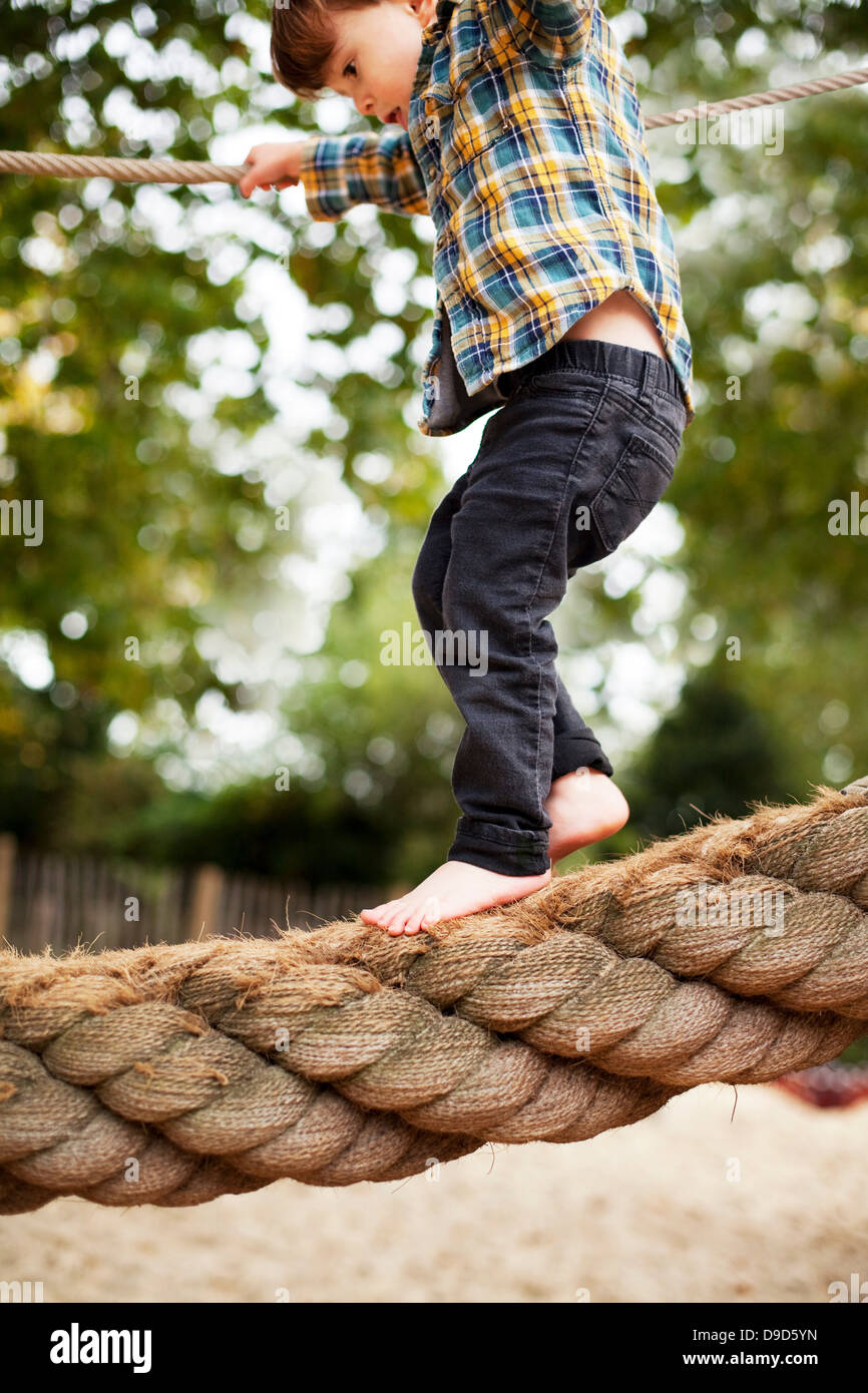 Male toddler crossing rope bridge Stock Photo