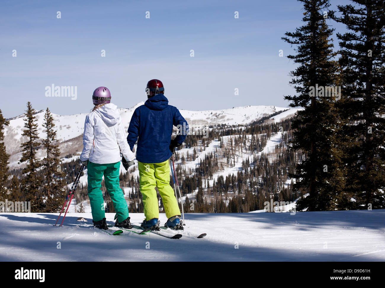 Young couple holding hands at top of ski run Stock Photo