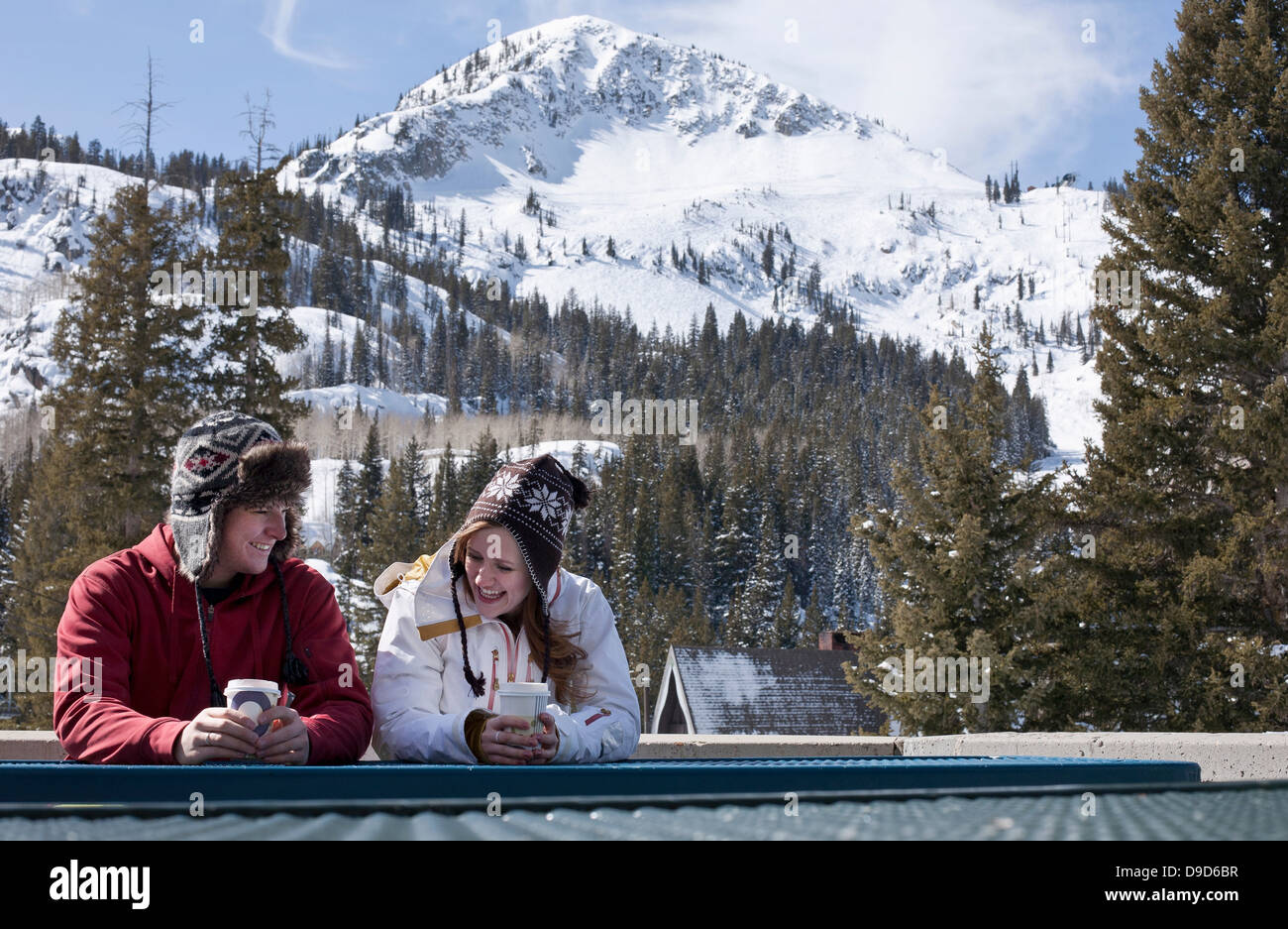 Young couple with hot drinks in Brighton ski resort, Utah, USA Stock Photo