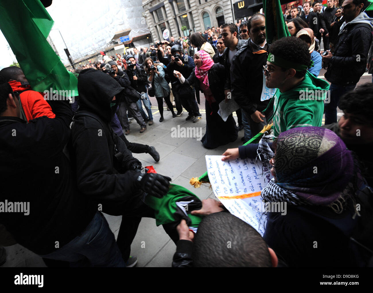Libyan pro Gaddafi supporters violently attack a group of protesters carrying the flag of the Libyan rebels during the March for the Alternative - TUC demonstration in Central London. London, England - 26.03.11 Stock Photo