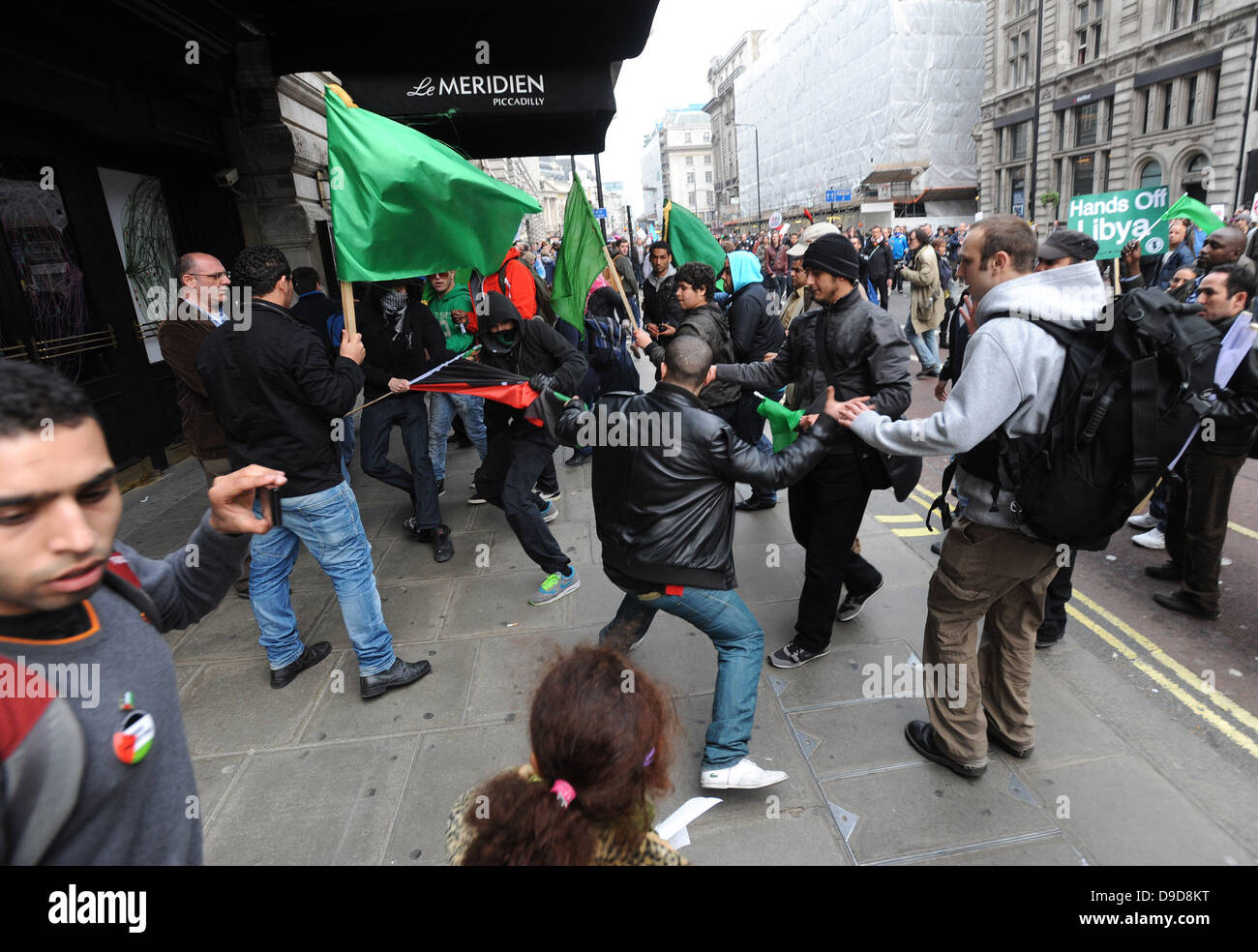 Libyan pro Gaddafi supporters violently attack a group of protesters carrying the flag of the Libyan rebels during the March for the Alternative - TUC demonstration in Central London. London, England - 26.03.11 Stock Photo