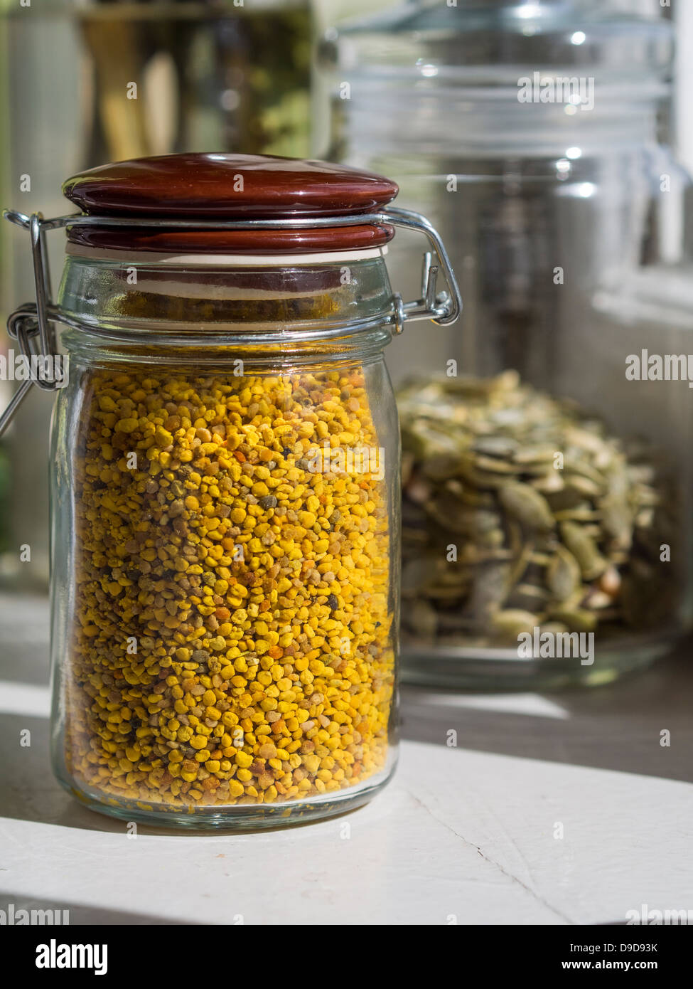 Pollen in a glass jar on a wooden table. Stock Photo
