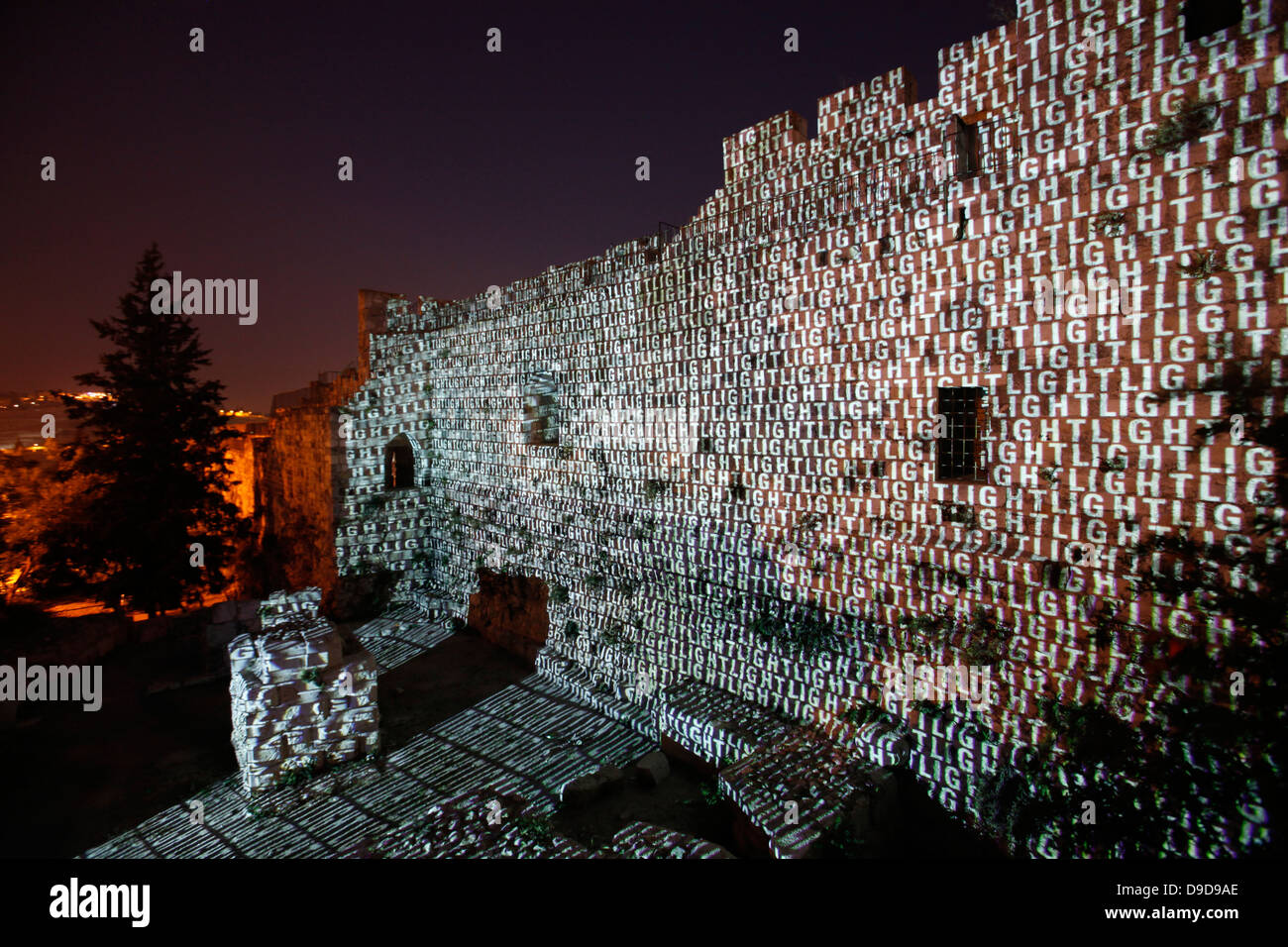 The word Light in English is projected onto old city walls during the Jerusalem Festival of Light in Israel which takes place annually around the old city with special effects illuminating historical sites and displays the work of leading international artists. Stock Photo