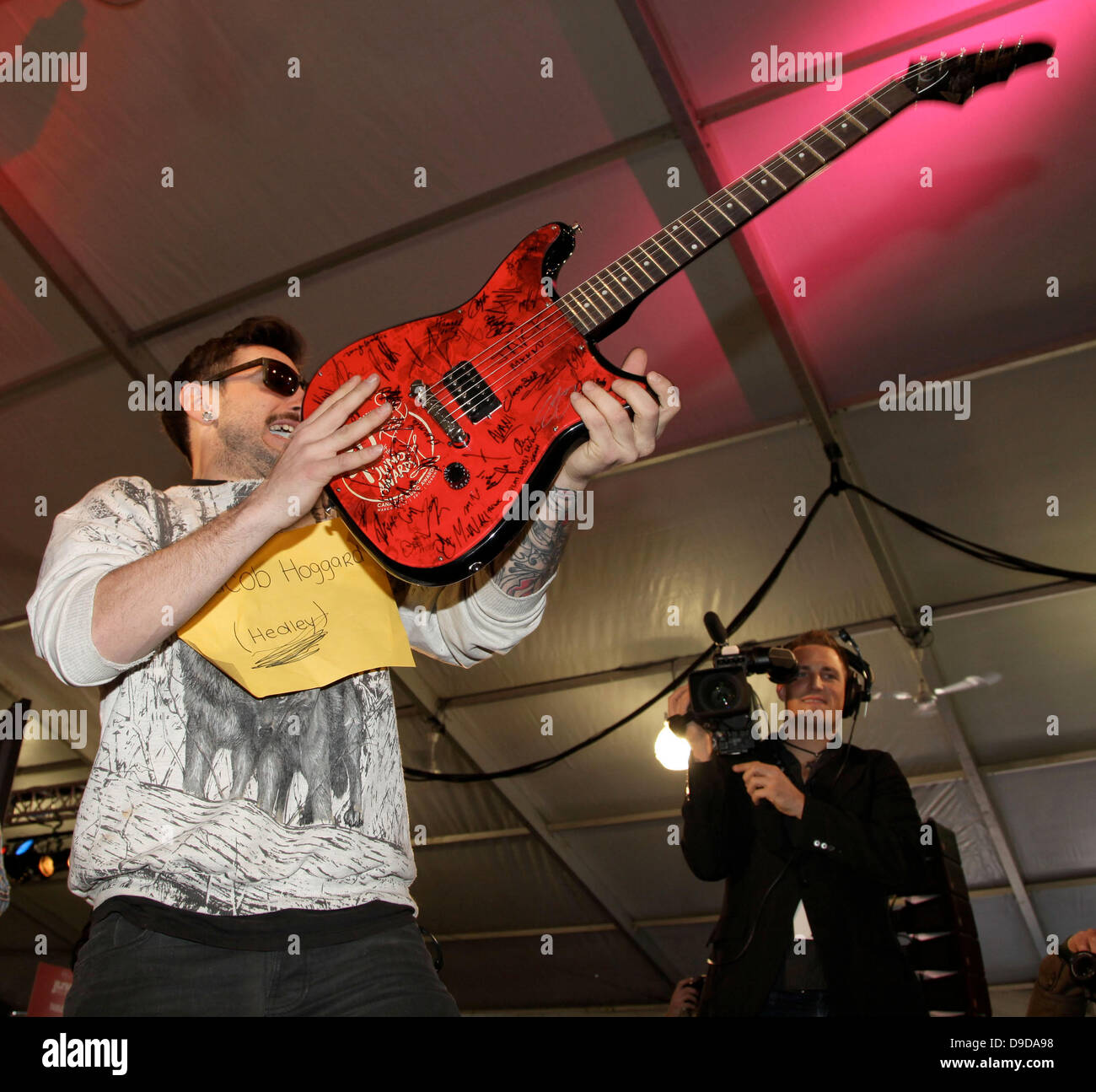 Jacob Hoggard lead singer of Hedley presents a guitar signed by all the