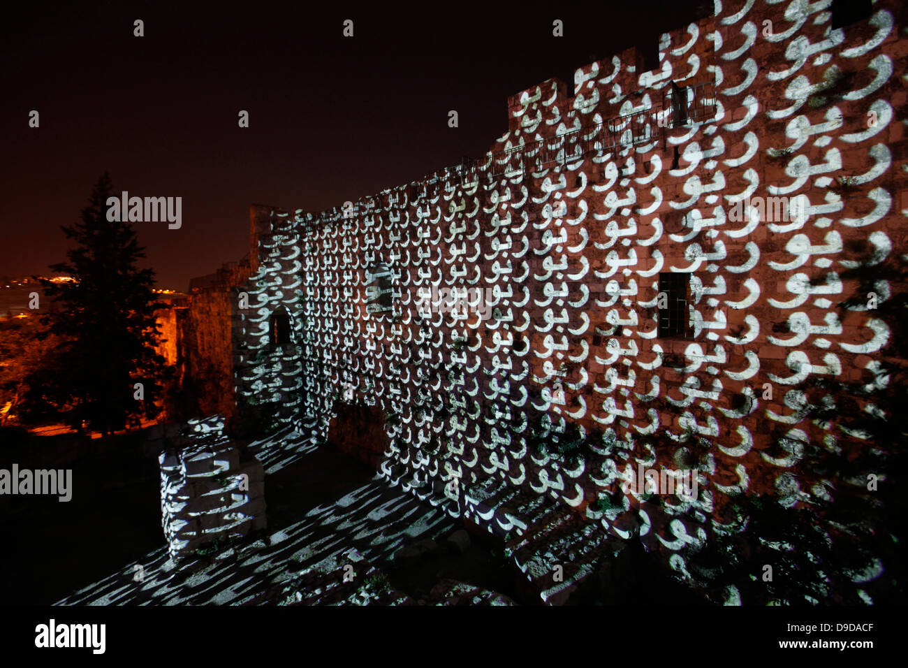 The word Light in Arabic is projected onto old city walls during the Jerusalem Festival of Light in Israel which takes place annually around the old city with special effects illuminating historical sites and displays the work of leading international artists. Stock Photo