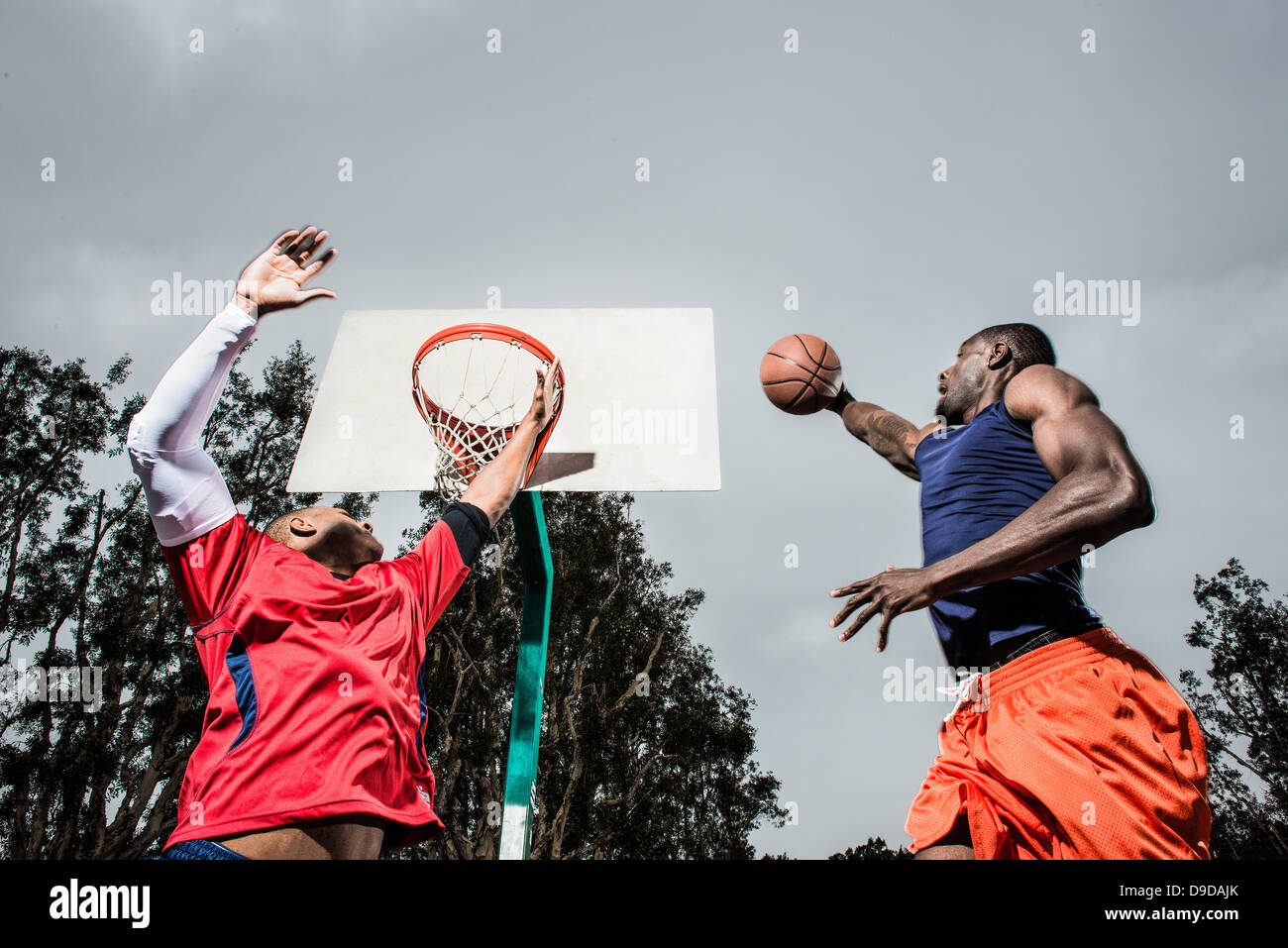 Young basketball players jumping to score hoop Stock Photo Alamy