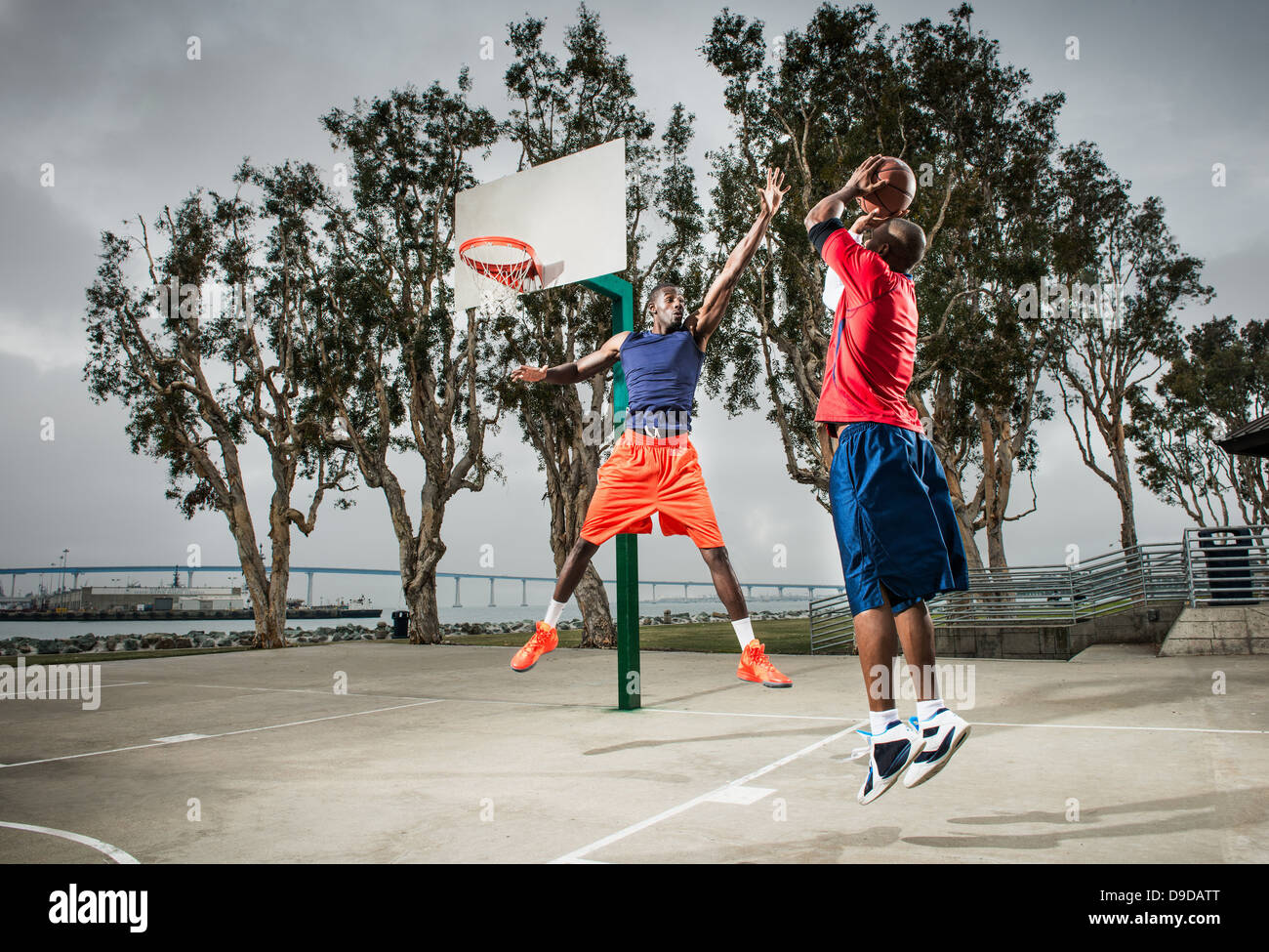 Young basketball players jumping to score hoop Stock Photo Alamy