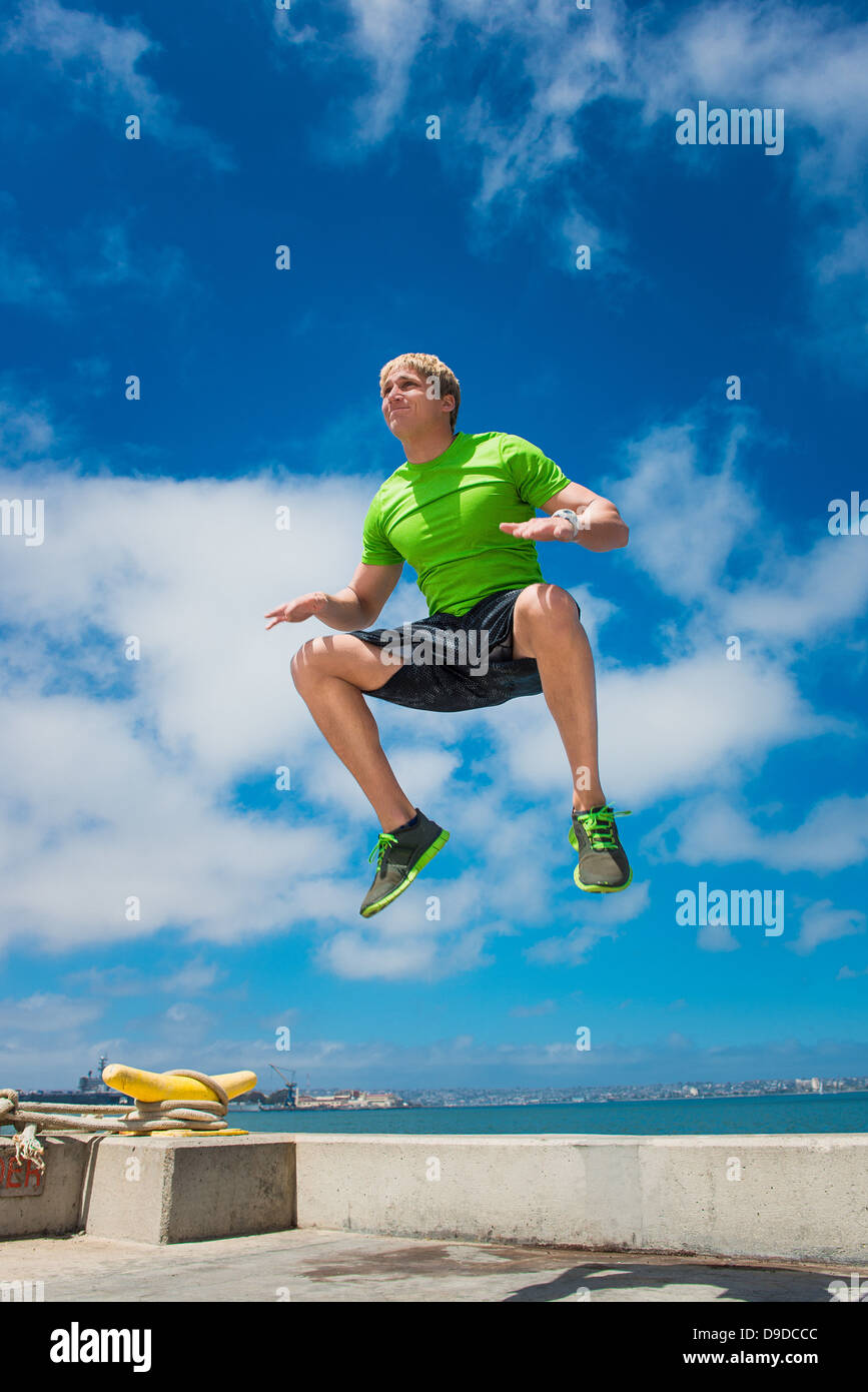 Young man jumping while fitness training Stock Photo Alamy