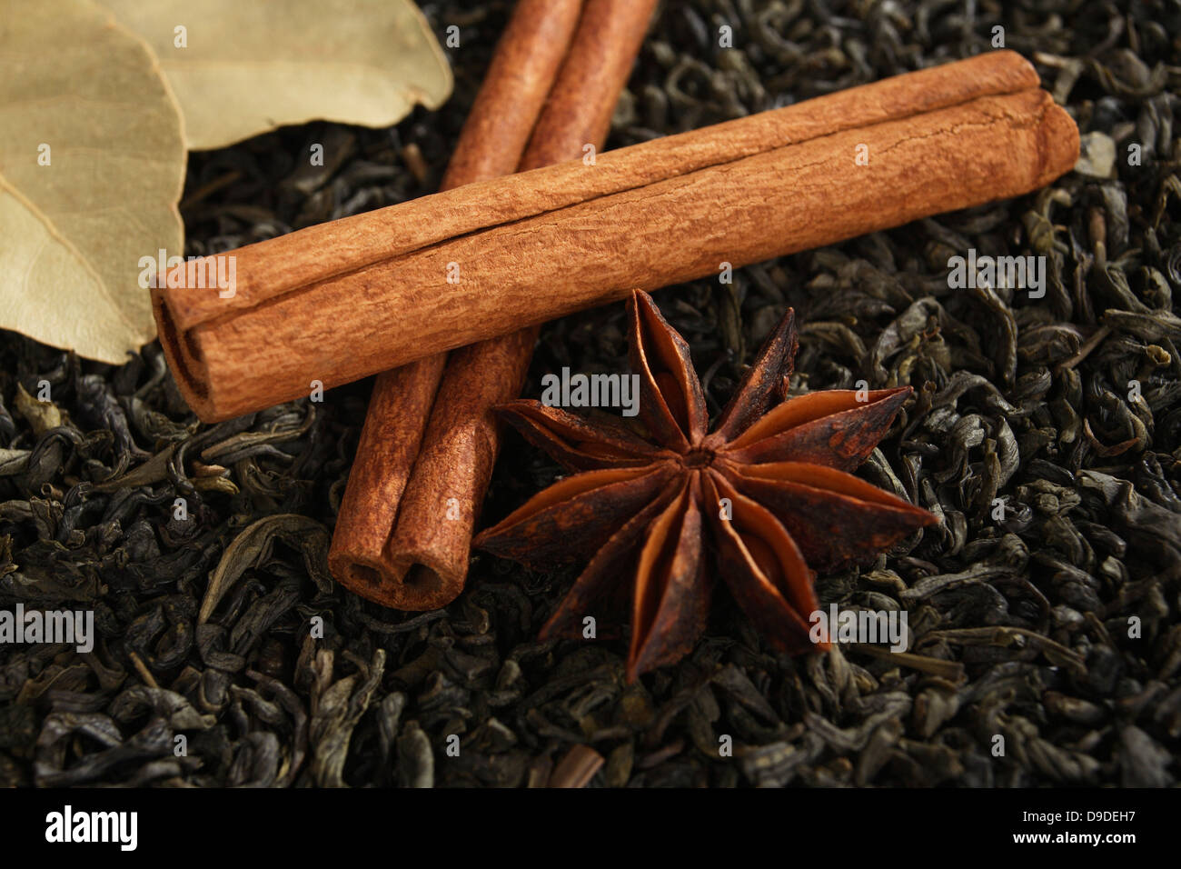 Aniseed star, cinnamon sticks, bay leaves with tea mixture Stock Photo