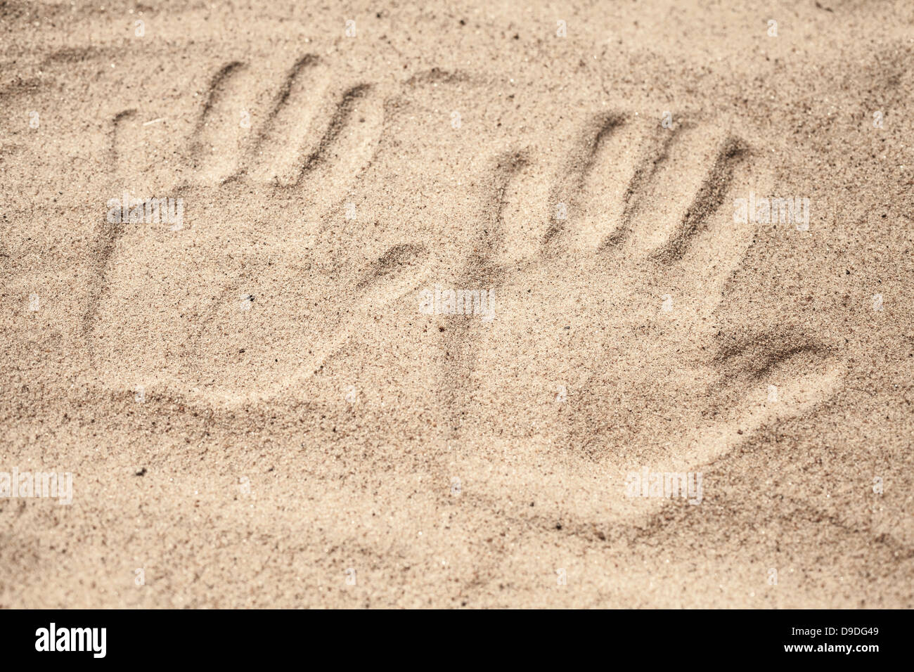 Two hand prints in the beach sand Stock Photo