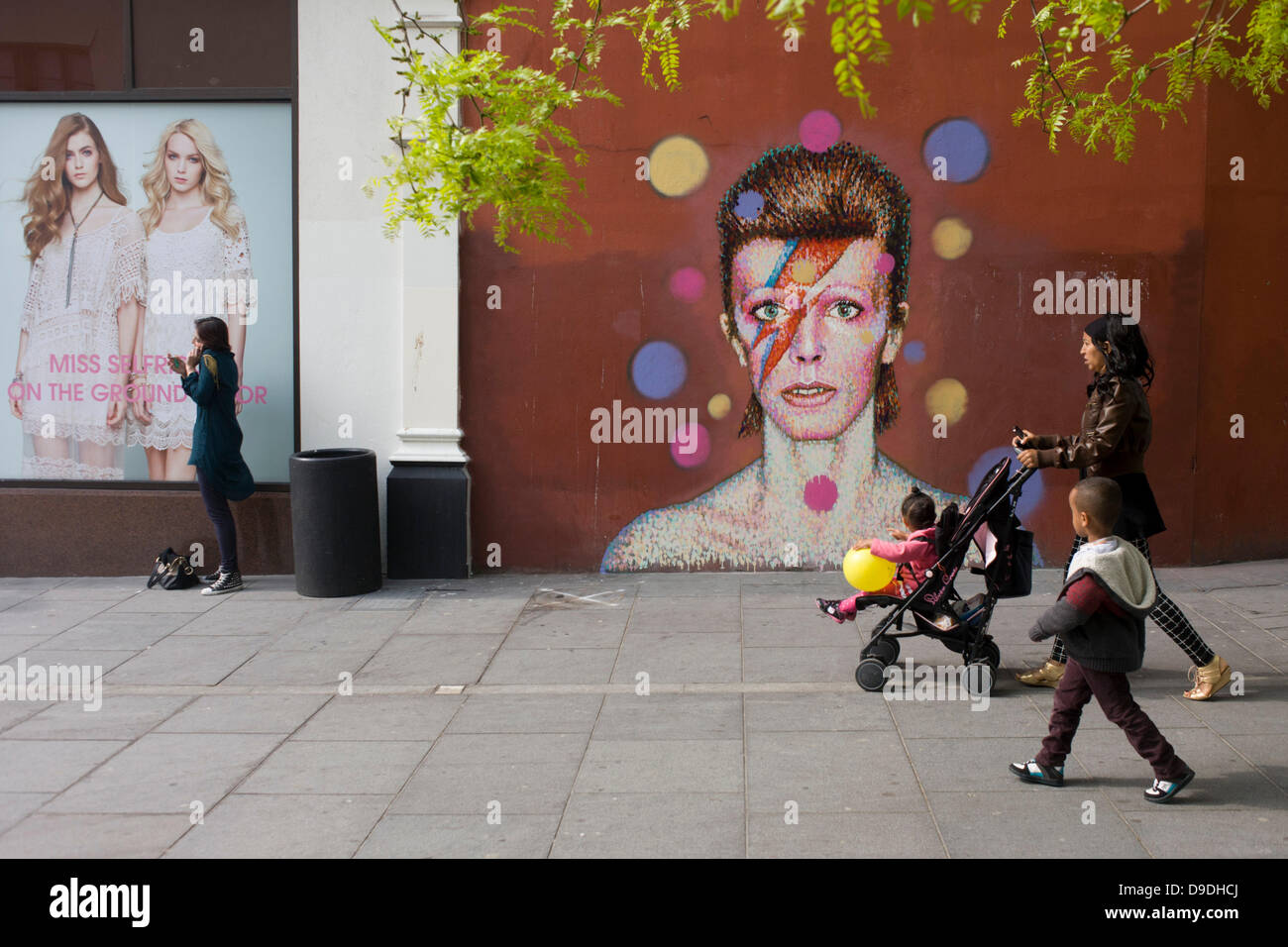 Brixton, London: 18th June 2013 - A mural of iconic musician and singer David Bowie has appeared on the wall of Morleys department store in Brixton, Lambeth, south London. The Bowie face is sourced (by artist James Cochran, aka Jimmy C) from the cover of his 1973 album Aladdin Sane at the height of his 1970s fame. The pop icon lived at 40 Stansfield Road, Brixton, from his birth in 1947 until 1953. This cover appeared in Rolling Stone’s list of the 500 greatest albums of all time, making #277. Credit: Richard Baker / Alamy Live News Stock Photo