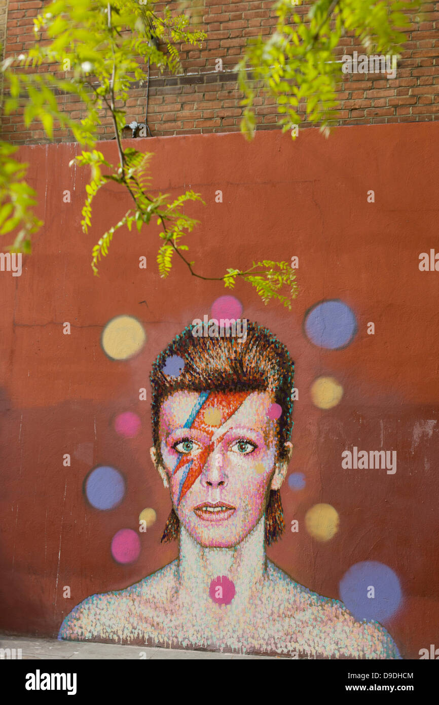 Brixton, London: 18th June 2013 - A mural of iconic musician and singer David Bowie has appeared on the wall of Morleys department store in Brixton, Lambeth, south London. The Bowie face is sourced (by artist James Cochran, aka Jimmy C) from the cover of his 1973 album Aladdin Sane at the height of his 1970s fame. The pop icon lived at 40 Stansfield Road, Brixton, from his birth in 1947 until 1953. This cover appeared in Rolling Stone’s list of the 500 greatest albums of all time, making #277. Credit: Richard Baker / Alamy Live News Stock Photo
