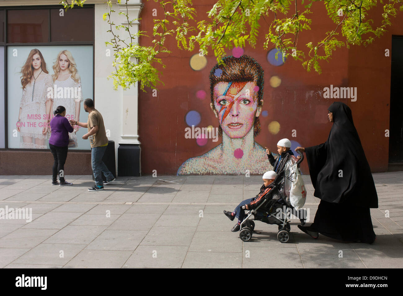 Brixton, London: 18th June 2013 - A mural of iconic musician and singer David Bowie has appeared on the wall of Morleys department store in Brixton, Lambeth, south London. The Bowie face is sourced (by artist James Cochran, aka Jimmy C) from the cover of his 1973 album Aladdin Sane at the height of his 1970s fame. The pop icon lived at 40 Stansfield Road, Brixton, from his birth in 1947 until 1953. This cover appeared in Rolling Stone’s list of the 500 greatest albums of all time, making #277. Credit: Richard Baker / Alamy Live News Stock Photo