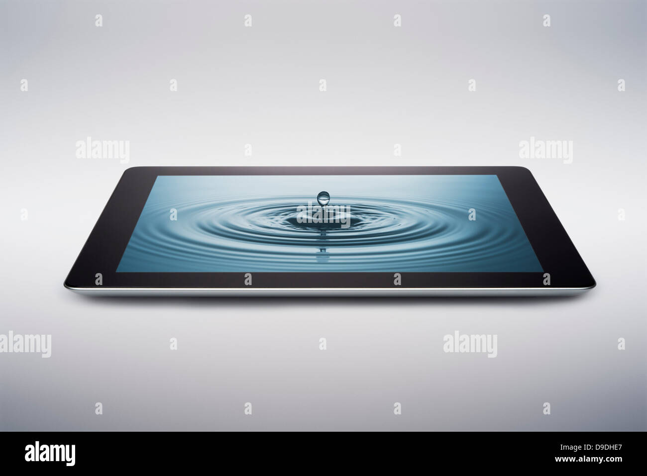 Digital tablet with water drop on screen Stock Photo