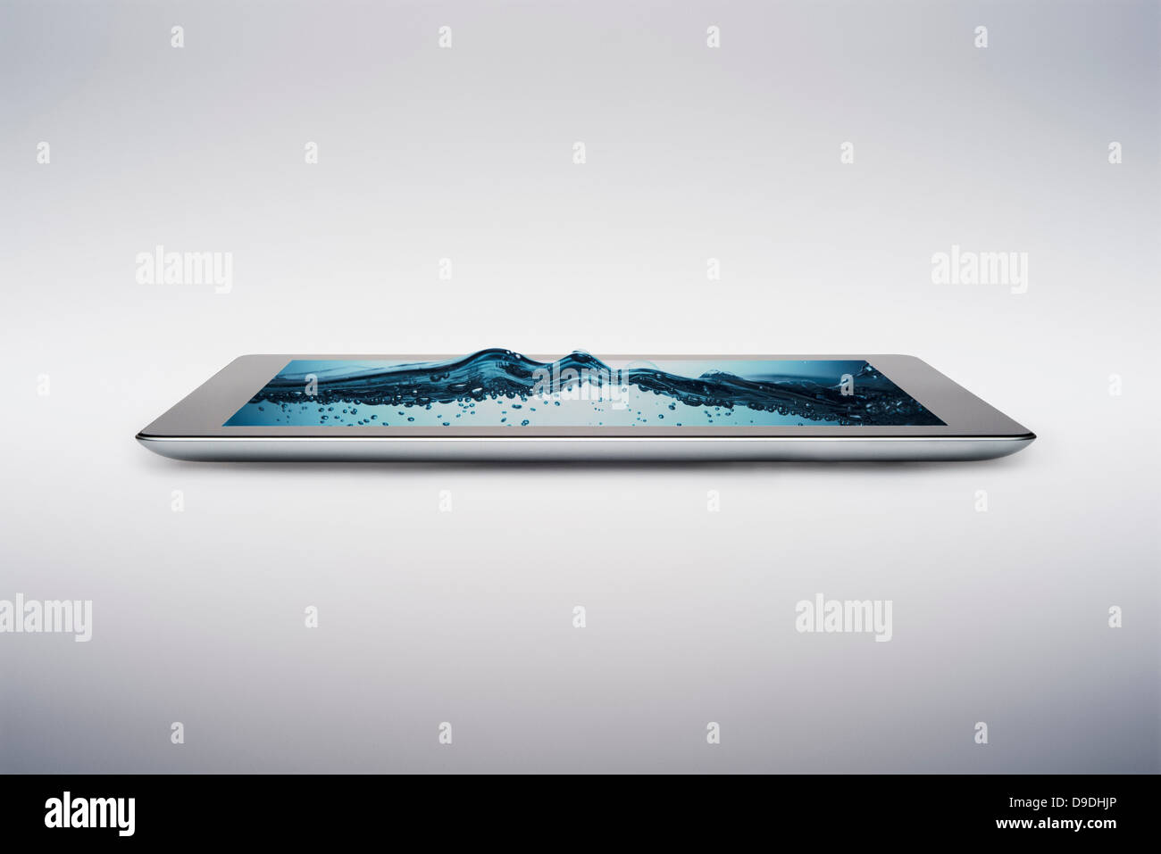 Digital tablet with gently rising bubbling water on screen Stock Photo